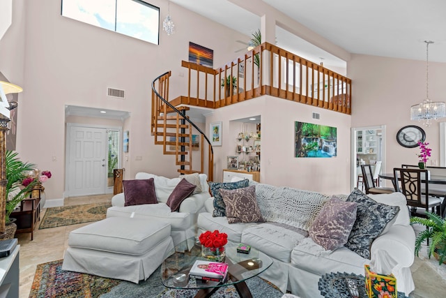 living room with an inviting chandelier, plenty of natural light, stairway, and a high ceiling