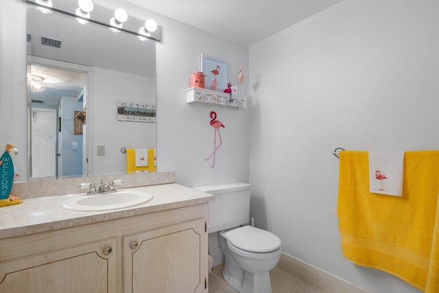 bathroom with vanity, tile patterned flooring, and toilet