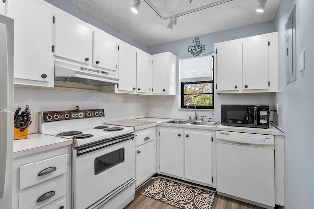 kitchen with white appliances, sink, track lighting, and a textured ceiling