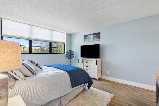 bedroom with hardwood / wood-style flooring and a textured ceiling