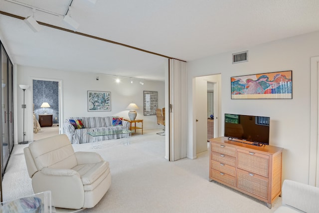 living room featuring track lighting and light carpet