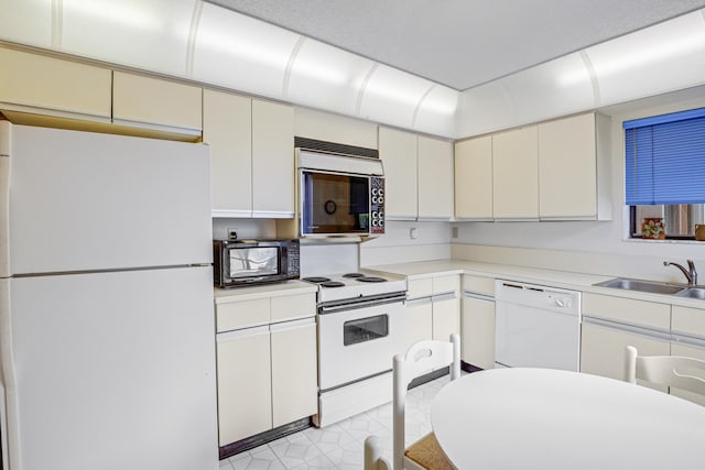 kitchen featuring white appliances and sink