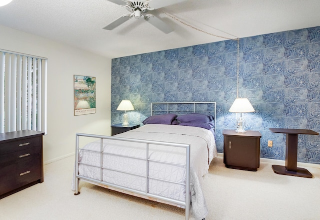 bedroom featuring a textured ceiling, ceiling fan, and carpet floors