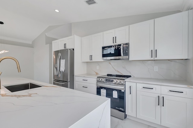 kitchen with light stone countertops, backsplash, stainless steel appliances, vaulted ceiling, and white cabinets