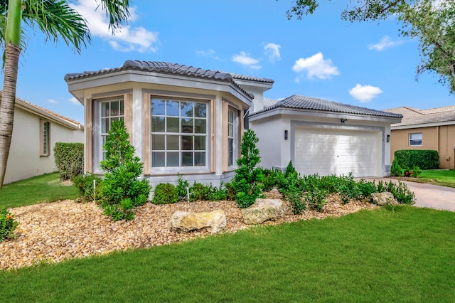 mediterranean / spanish-style house featuring a front yard and a garage