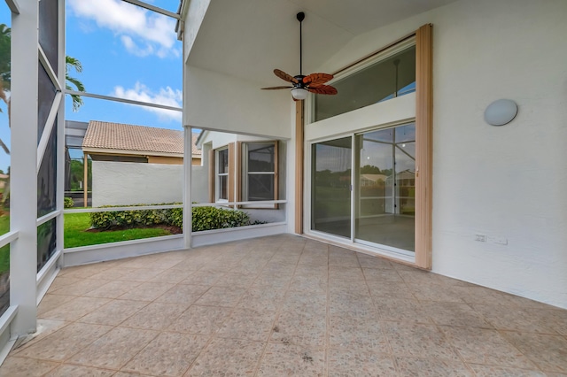 unfurnished sunroom with ceiling fan