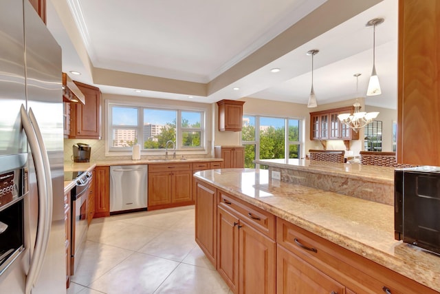 kitchen featuring light stone countertops, sink, stainless steel appliances, range hood, and a chandelier