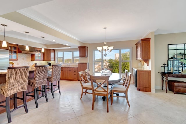 tiled dining space with crown molding, sink, and an inviting chandelier