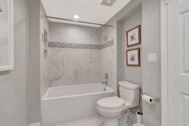 bathroom with toilet and tiled shower / bath