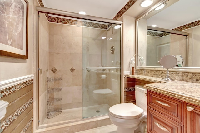 bathroom with tile walls, vanity, an enclosed shower, and toilet