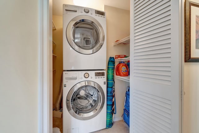 clothes washing area featuring stacked washer and clothes dryer