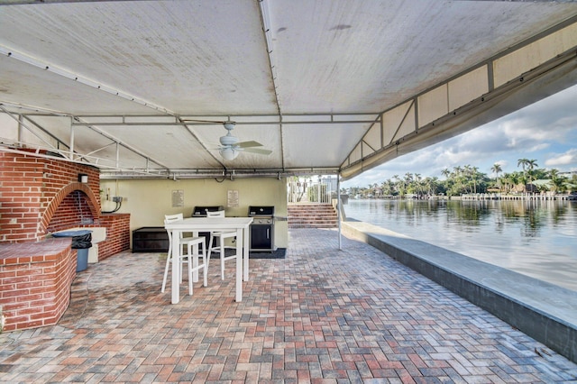 view of patio / terrace with area for grilling, ceiling fan, and a water view