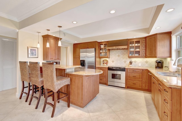 kitchen with sink, decorative light fixtures, a kitchen bar, a kitchen island, and appliances with stainless steel finishes