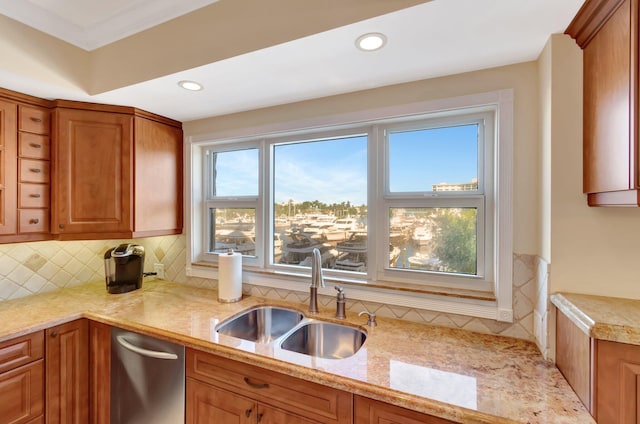 kitchen featuring light stone countertops, dishwasher, sink, backsplash, and crown molding