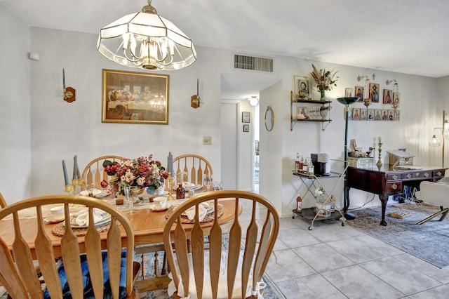 tiled dining space featuring an inviting chandelier