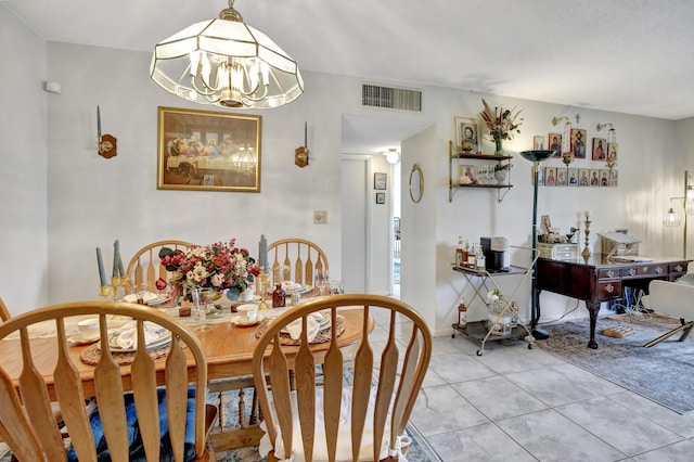 dining area with light tile patterned flooring and a chandelier
