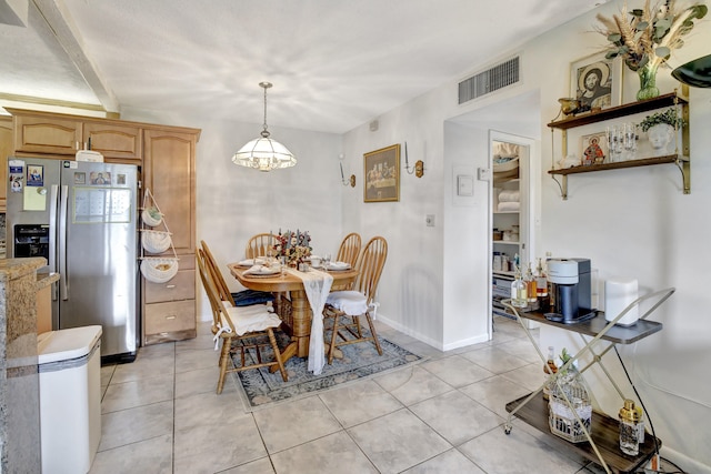 tiled dining room with a chandelier