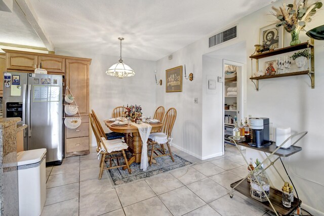 dining area featuring light tile patterned flooring and baseboards