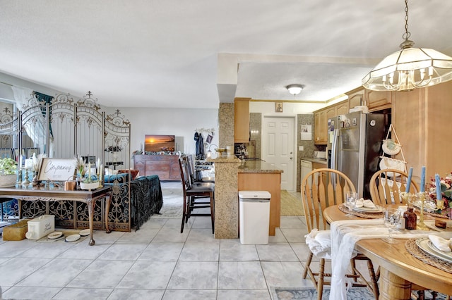 tiled dining room featuring a notable chandelier