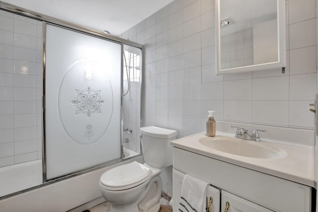 bathroom featuring tile walls, bath / shower combo with glass door, toilet, vanity, and backsplash