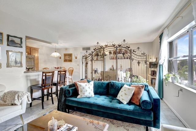 tiled living room featuring a textured ceiling