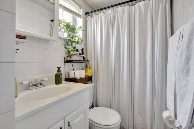 bathroom with toilet, tile walls, walk in shower, vanity, and decorative backsplash