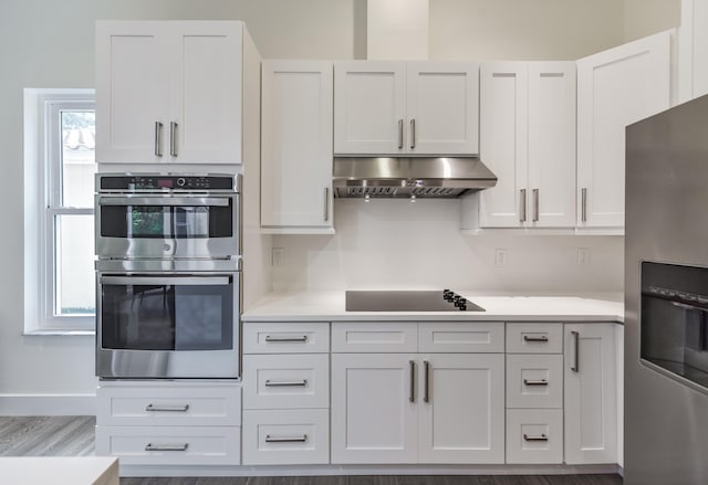 kitchen with white cabinetry, hardwood / wood-style floors, and stainless steel appliances