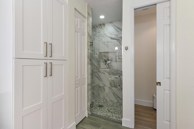 bathroom featuring hardwood / wood-style floors and a shower with shower door