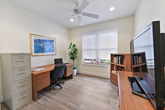 home office with light hardwood / wood-style floors and ceiling fan