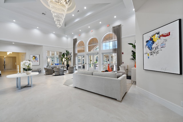 living room featuring a towering ceiling, a tray ceiling, french doors, and a notable chandelier