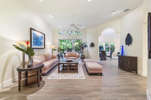 living room featuring high vaulted ceiling, light hardwood / wood-style floors, and ceiling fan