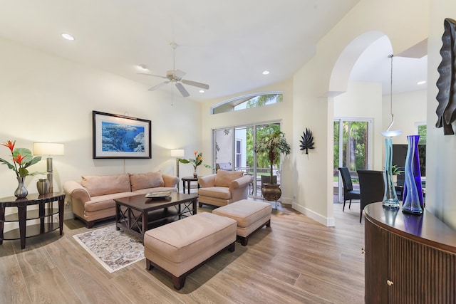 living room featuring ceiling fan, light hardwood / wood-style flooring, and high vaulted ceiling