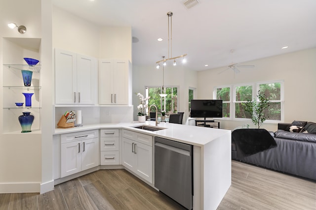 kitchen featuring light hardwood / wood-style flooring, stainless steel dishwasher, hanging light fixtures, and white cabinets