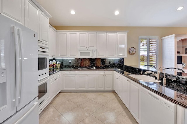 kitchen with white cabinetry, sink, tasteful backsplash, dark stone counters, and white appliances