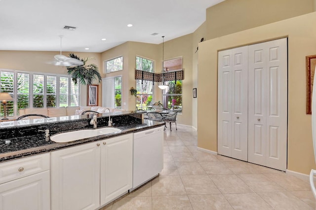 kitchen with dishwasher, white cabinets, sink, decorative light fixtures, and dark stone countertops