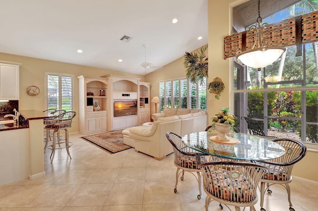 tiled dining area featuring a healthy amount of sunlight and lofted ceiling