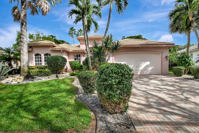 mediterranean / spanish-style house with a front lawn and a garage