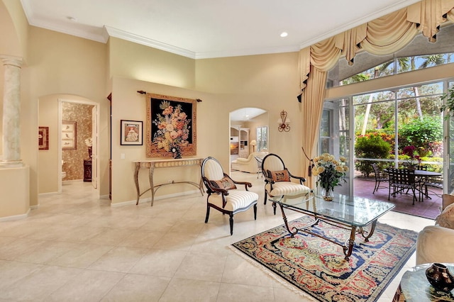 interior space featuring a high ceiling, decorative columns, and crown molding