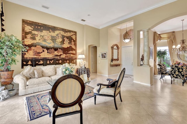 tiled living room with crown molding, decorative columns, and an inviting chandelier