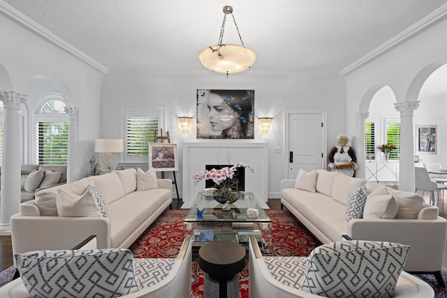 living room with crown molding, wood-type flooring, and decorative columns