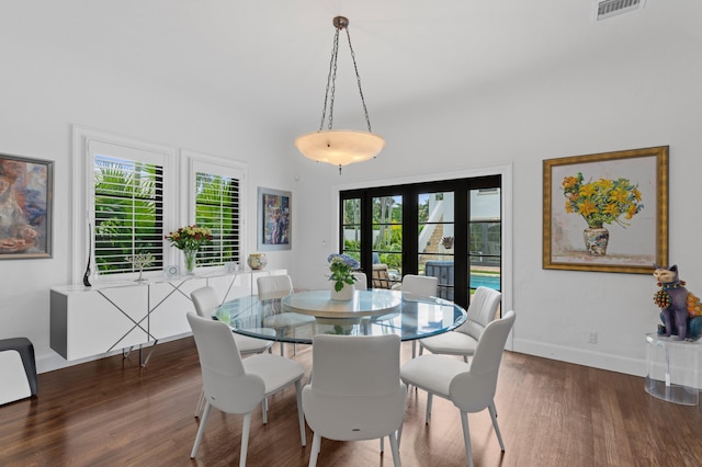 dining space with french doors, a healthy amount of sunlight, and dark hardwood / wood-style floors