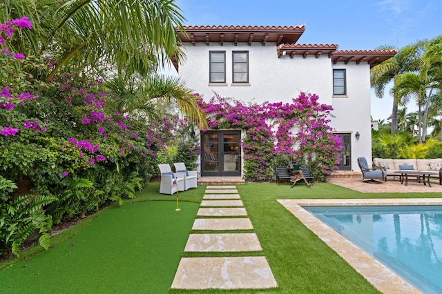 back of property featuring a patio, french doors, a lawn, and an outdoor hangout area