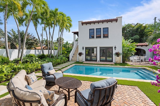 view of pool with french doors and a patio