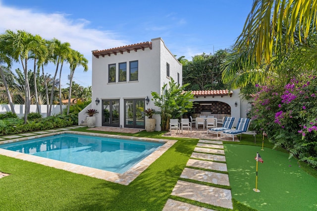 rear view of house with a patio and a fenced in pool