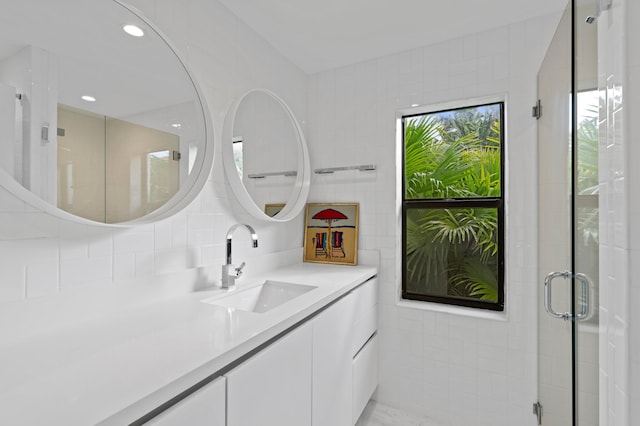 bathroom featuring tile walls, vanity, a shower with shower door, and tasteful backsplash