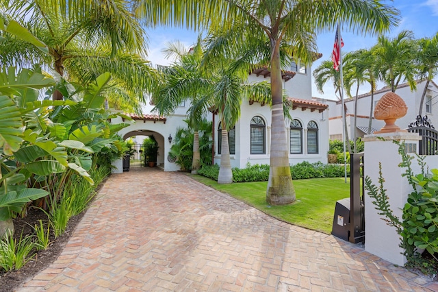 mediterranean / spanish home featuring a front yard and a carport