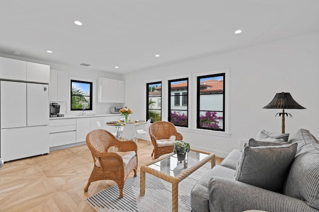 living room featuring light parquet flooring and sink