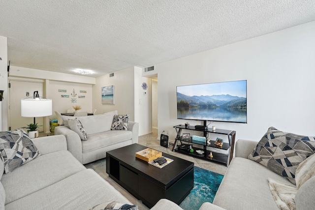 tiled living room featuring a textured ceiling