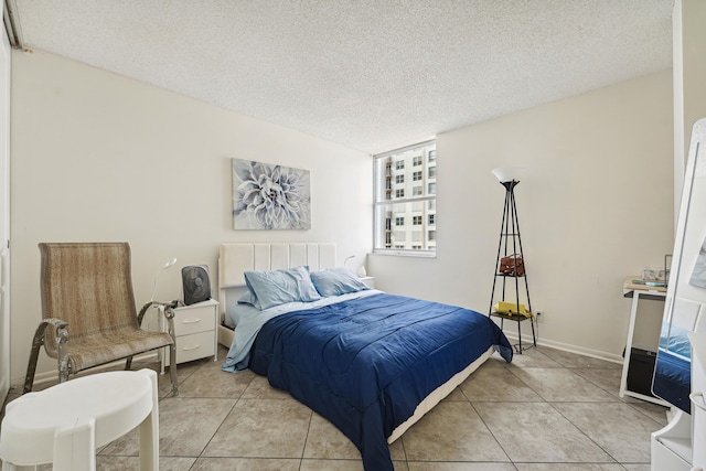 bedroom with a textured ceiling and light tile patterned floors