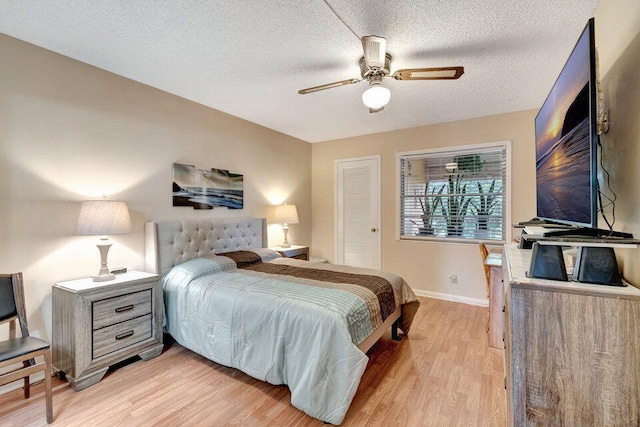 bedroom with ceiling fan, a textured ceiling, and light wood-type flooring